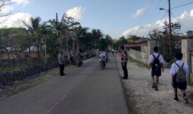 Pengaturan Lalin Pagi, Personel Polsek Rote Selatan Bantu Anak Sekolah Menyebrang Jalan