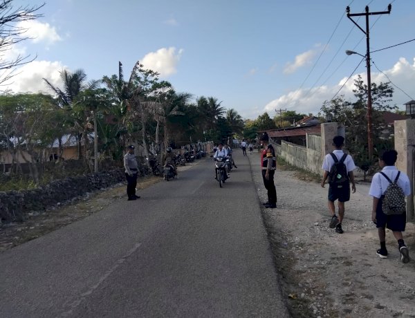 Pengaturan Lalin Pagi, Personel Polsek Rote Selatan Bantu Anak Sekolah Menyebrang Jalan